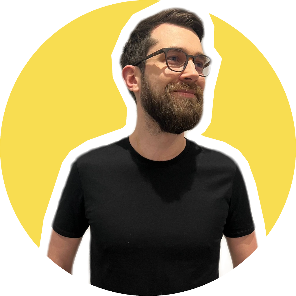 Portrait of a friendly bearded man in his 30s, founder of an EdTech startup, smiling warmly, studio lighting